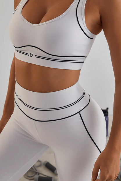 Model wearing a trendy white sports bra and high-waist leggings with black detailing, showcasing comfort and style.